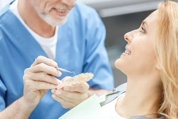 Стоматолог, що відповідає кольору зубів — стокове фото