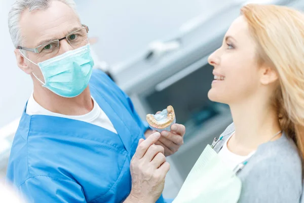 Dentista mostrando modelo de mandíbulas — Fotografia de Stock