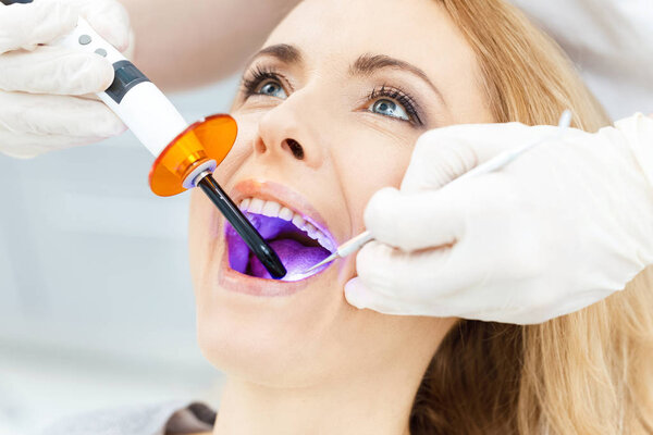 Patient whitening teeth at dentist