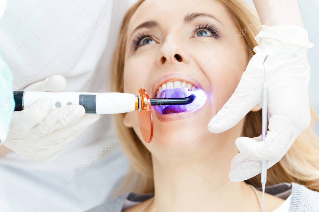 Patient whitening teeth at dentist