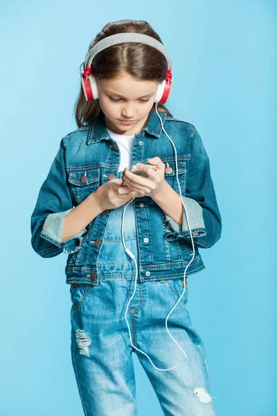 Flicka i hörlurar med smartphone — Stockfoto