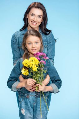 Anne ve kızı çiçek tutan