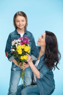 Anne ve kızı çiçek tutan