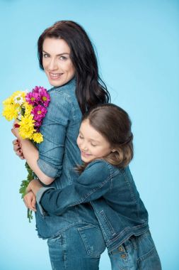 Anne ve kızı çiçek tutan