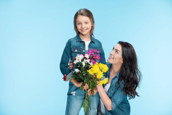 mother and daughter holding flowers