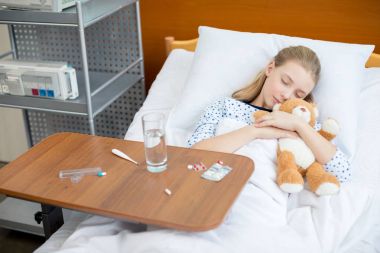 Little girl in hospital bed  clipart