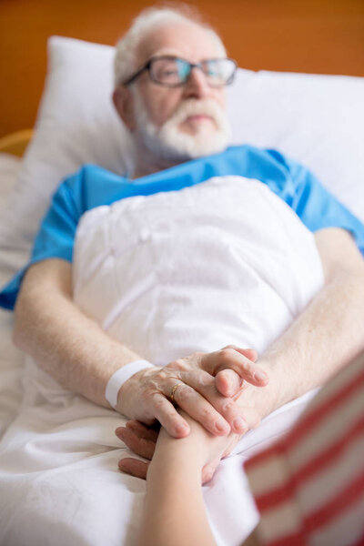 senior patient holding hands 