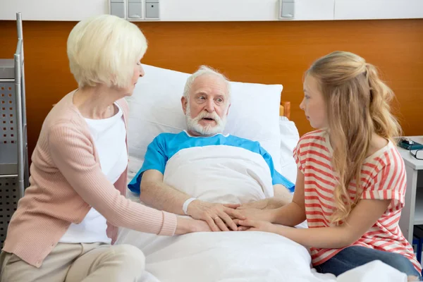 Бабуся і дідусь тримають руки з пацієнтом — стокове фото