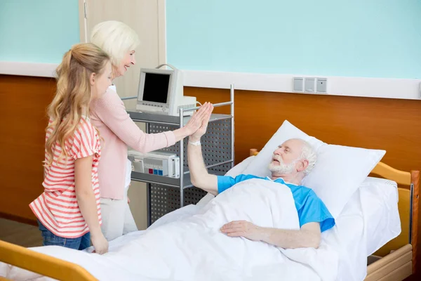 Бабушка и внучка навещают пациента — стоковое фото