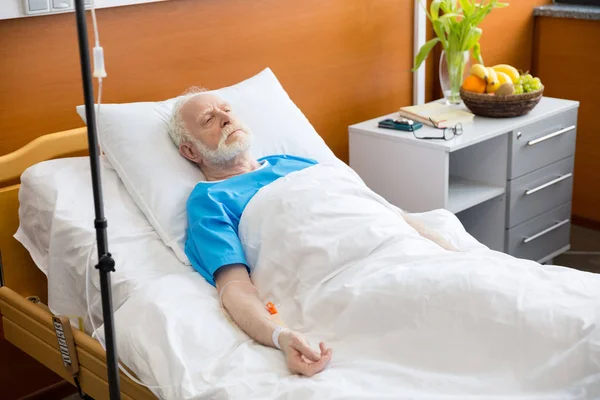 Старший чоловік у лікарняному ліжку — стокове фото