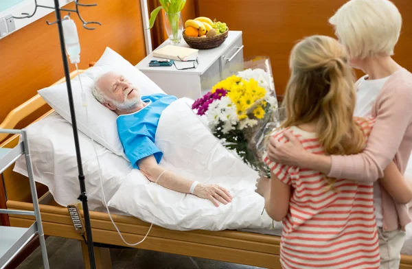 Relatives with senior man in hospital — Stock Photo, Image