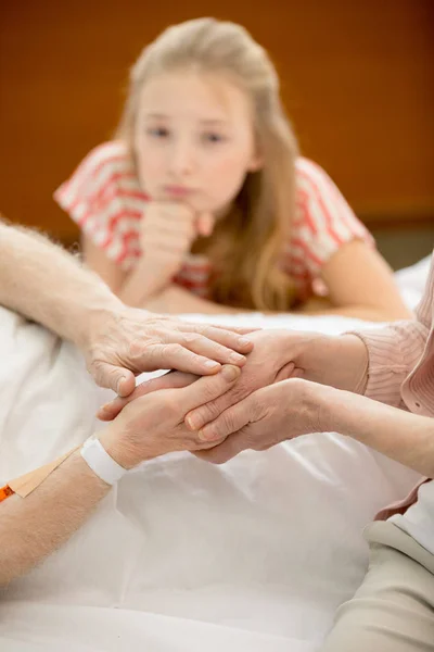 Relatives with senior man in hospital — Stock Photo, Image