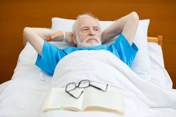 Senior man in hospital bed — Free Stock Photo