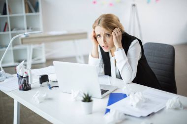 Stressed businesswoman at workplace  clipart