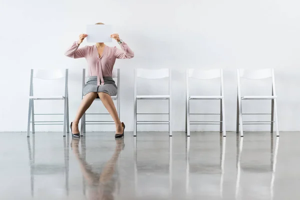 Empresária cobrindo rosto com papel — Fotografia de Stock