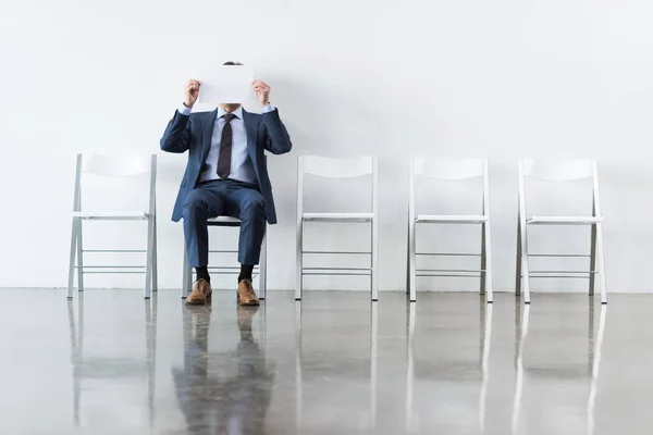 Businessman covering face with paper — Stock Photo, Image