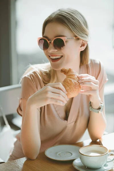 Menina com croissant no café — Fotografia de Stock