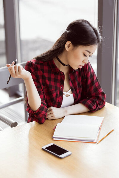 asian student studying in cafe