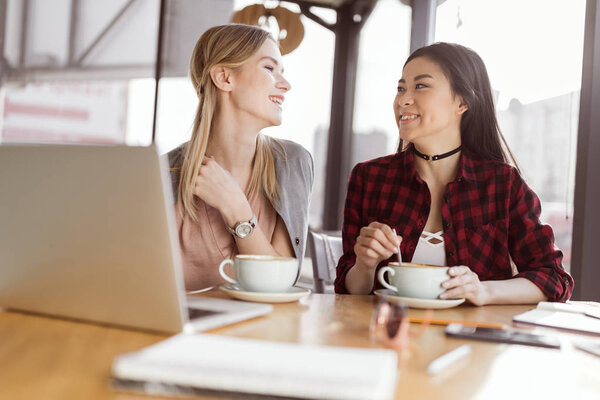 Молодые женщины пьют кофе
 