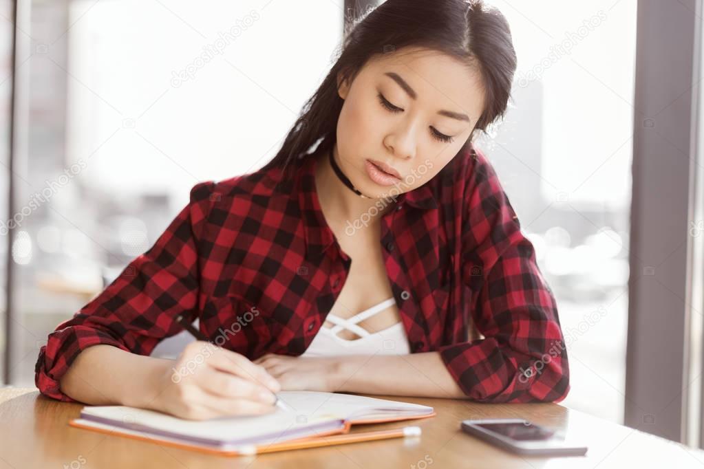 asian student studying in cafe