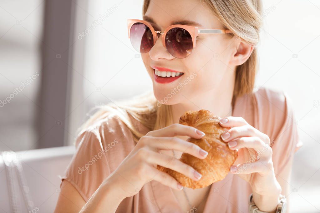 young woman eating croissant