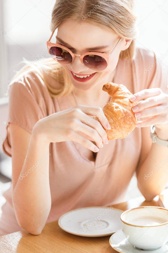young woman eating croissant