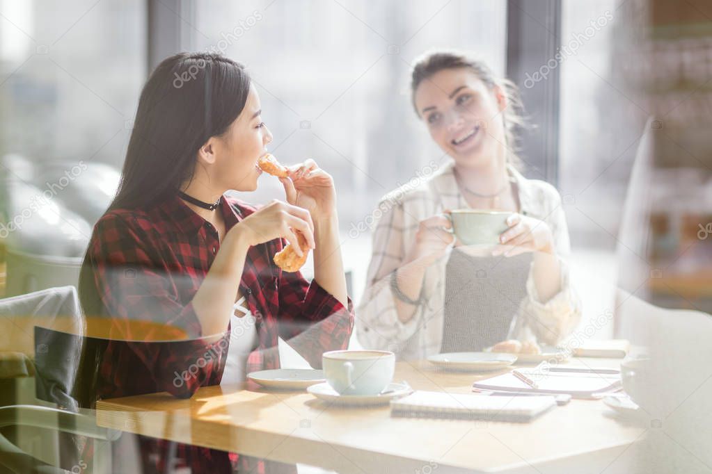 girls eating croissants and drinking coffee