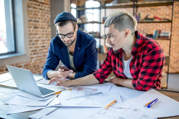 Arquitectos usando laptop y smartphone - foto de stock