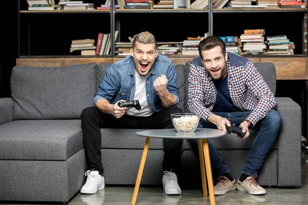 Men playing with joysticks — Stock Photo