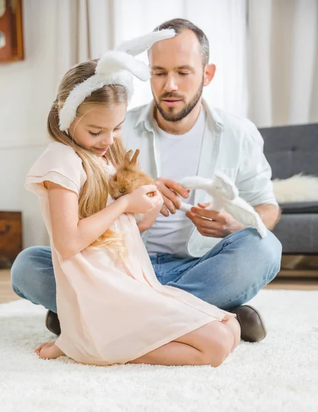 Father and daughter playing with rabbit — Stock Photo