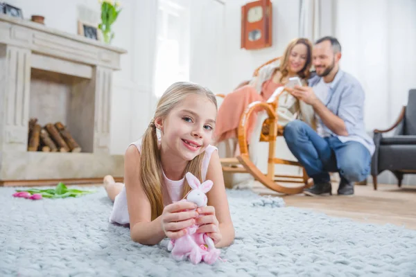 Girl playing with toy rabbit — Stock Photo