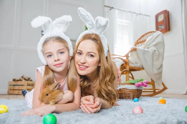 Mother and daughter playing with rabbit — Stock Photo