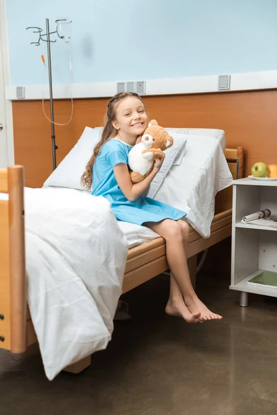 Pequeña paciente con oso de peluche - foto de stock