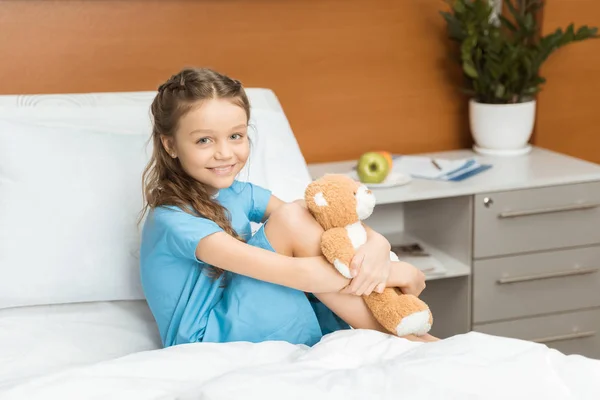 Pequeña paciente con oso de peluche - foto de stock