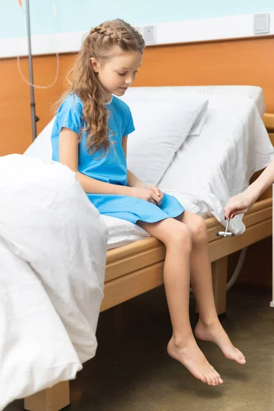 Petite patiente assise sur son lit — Photo de stock