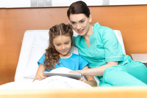 Médico y chica con tableta digital - foto de stock