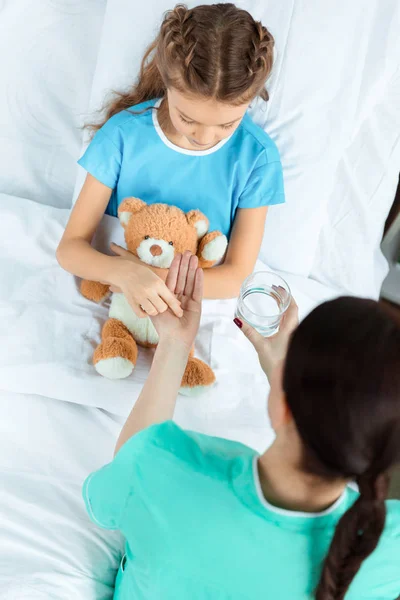 Médico dando pílula para o paciente — Fotografia de Stock