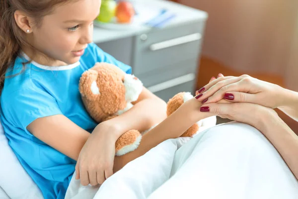 Doctor and patient holding hands — Stock Photo