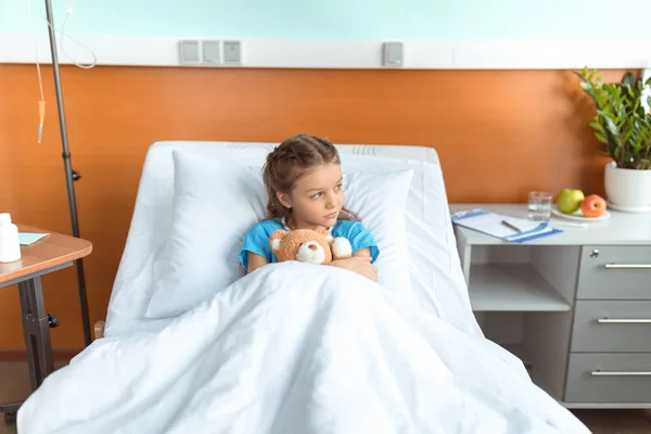 Pequeña paciente con oso de peluche - foto de stock