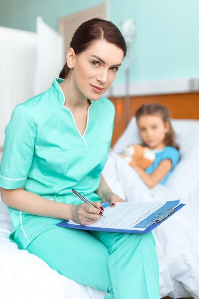 Niña y enfermera en el hospital - foto de stock