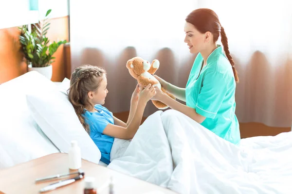 Niña y enfermera en el hospital - foto de stock