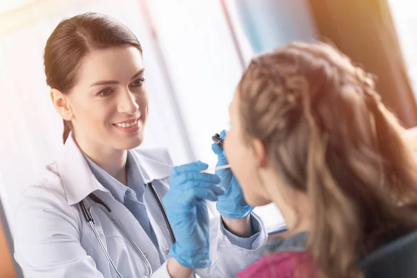 Médico chequeando garganta de chica - foto de stock