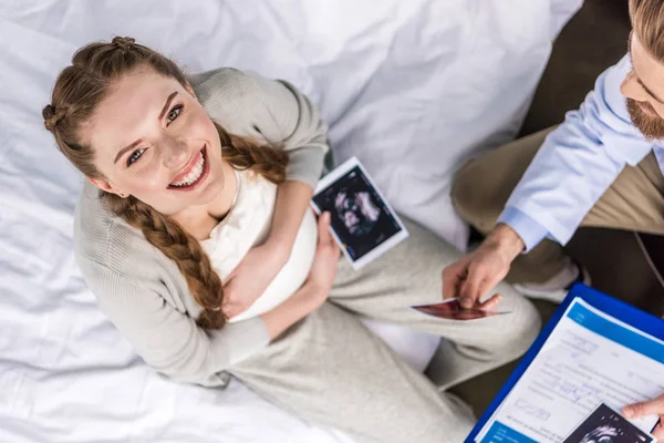 Médico y mujer con ecografías - foto de stock