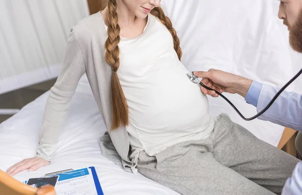 Médico examinando mujer embarazada - foto de stock