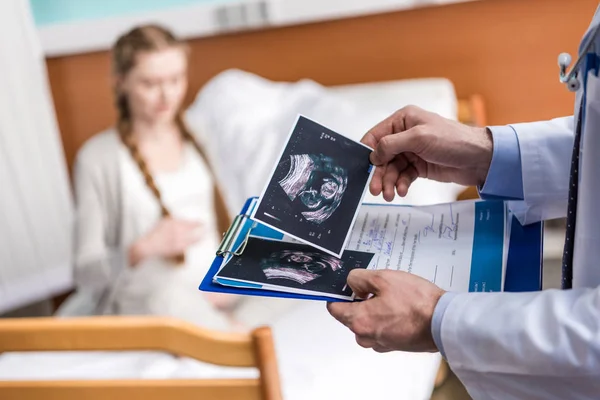 Doctor holding ultrasound scans — Stock Photo