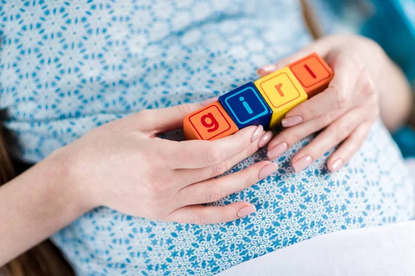 Pregnant woman with word girl — Stock Photo