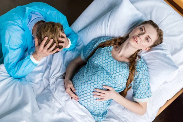 Mujer embarazada y hombre en el hospital - foto de stock