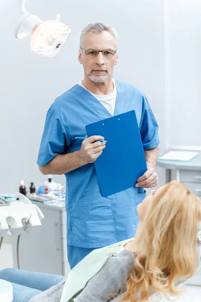 Dentista con paziente in clinica dentistica — Foto stock