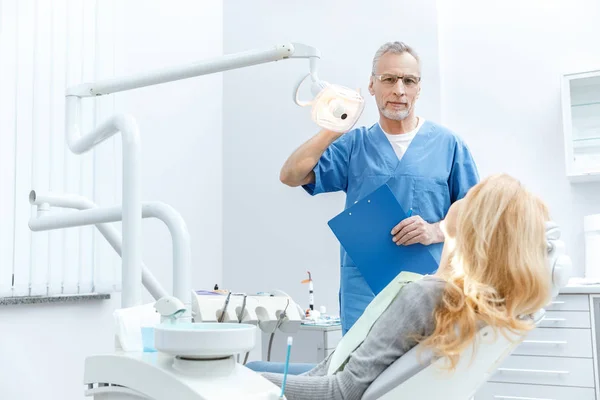 Dentista con paciente en clínica dental — Stock Photo