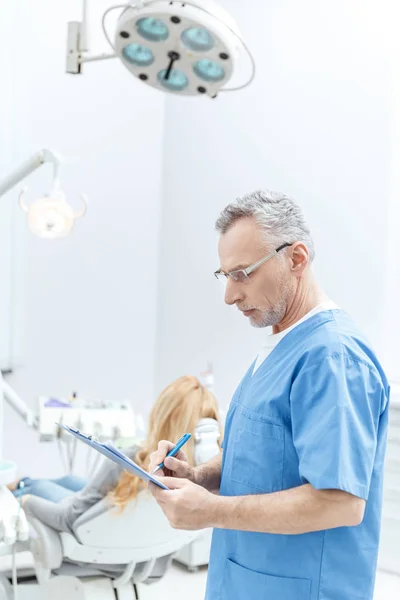 Dentista senior en uniforme - foto de stock